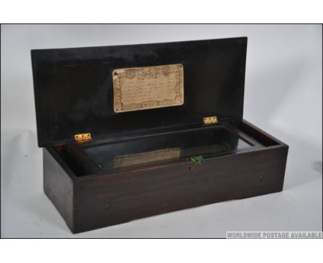 A 19th century Rosewood & Marquetry inlaid music box having 13" cylinder  and comb playing 6 airs. The hinged lid with menu f