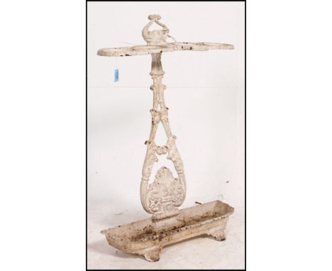 A Victorian Coalbrookdale style umbrella stand in cast iron with painted white finish. The tray to base with rococo upright a