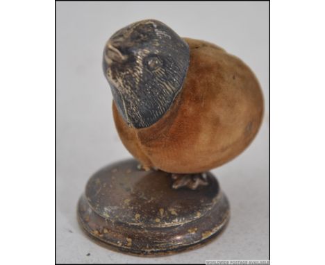 A stunning silver hallmarked pin cushion in the form of a small bird - chick raised on silver plinth base, the body of velvet