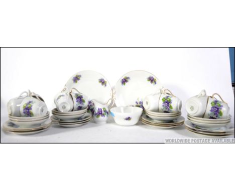 A twelve cover chintzy floral tea service, consisting of cups, trio's, creamer,  sugar bowl and bread plates. Stamped to the 