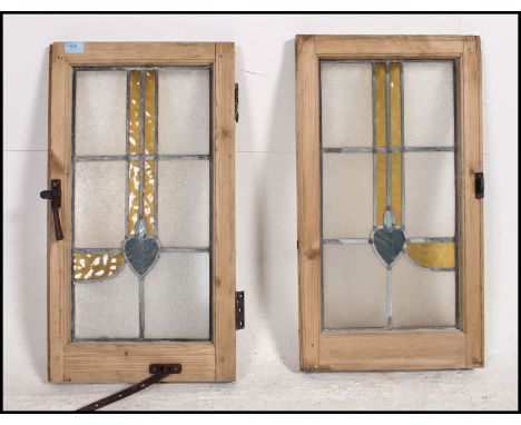 A matched pair of 1930's pine stained glass windows complete with the latches. The Art Nouveau design being a true pair to ea
