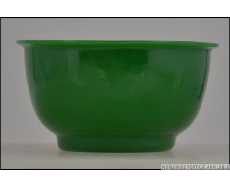 A hand blown peking glass bowl, the jade green mottled colour to the circular bowl. 11cms wide