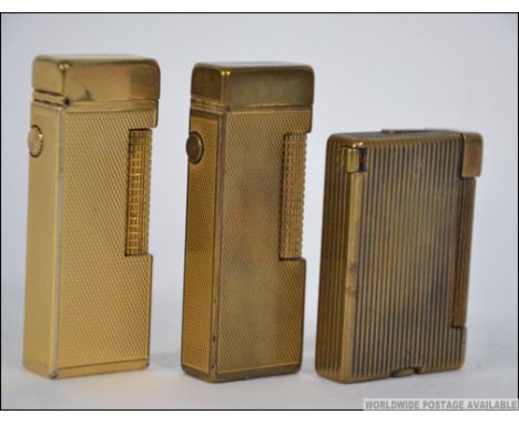 A collection of lighters to include 2 brass roller Dunhill lighters together with a Parker Beacon vintage lighter. Measures: 