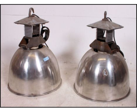 A large pair of mid century Industrial Holophane lined factory pendant shades. Each polished metal shade with stunning bracke