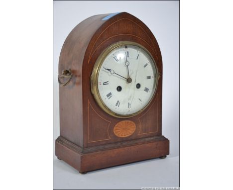 An Edwardian mahogany inlaid mantel clock in a spire shaped case with inlaid detail, 8 day timepiece and convex white dial. 2