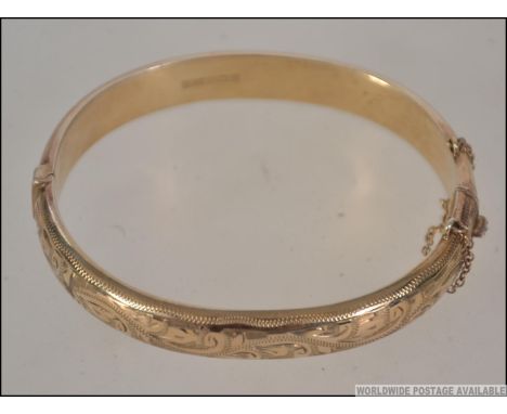 A hallmarked 9ct gold bangle bracelet. Hallmarked for Birmingham , maker L and Co. Weight 17.7g.
