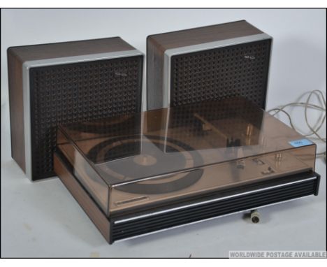 A retro late 1960's  Pye 1556 three speed stereo record player, having a smoked plastic cover and matching speakers. In worki