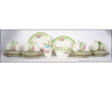 A late 18th / early 20th century bone china chintzy floral tea service, consisting of twelve trio's, creamer and sugar bowl.