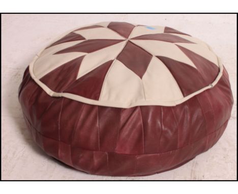 A retro two tone leather Morrocan style pouffe, having a cream and red leater geometric patch work design to the top. Measure