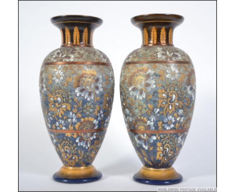 A Pair of Doulton Lambeth Art Nouveau stoneware glazes bases with trumpet flared tops with wheatsheaf design over bulbous bod