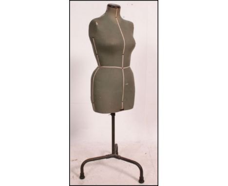 A vintage mid century Industrial shop / tailers haberdashery mannequin raised on tubular metal frame with green fabric torso.