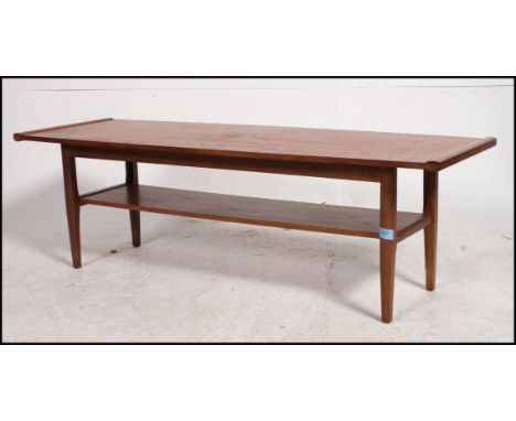 A 1970's retro Danish coffee table of rectangular form with inverse bow ends raised on squared and tapering supports