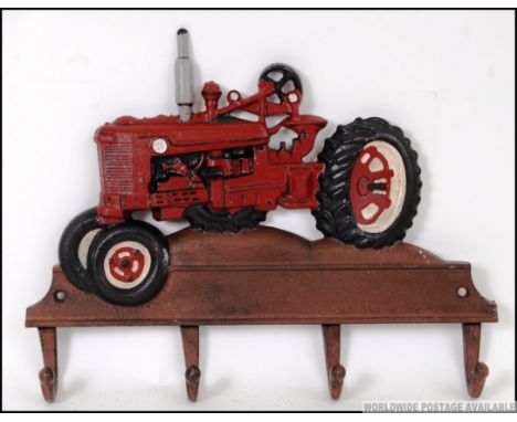 A cast iron coat rack / cup rack in the form of a vintage farm tractor. Hand painted.