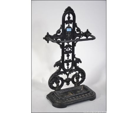 A Coalbrookdale style cast iron two division  stick stand, painted white with scroll and floral mounts to shaped base, drip t