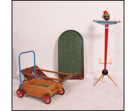 A collection of retro wooden toys to include a decorative wooden childs clothes hanger in the form of a figure, a push along 