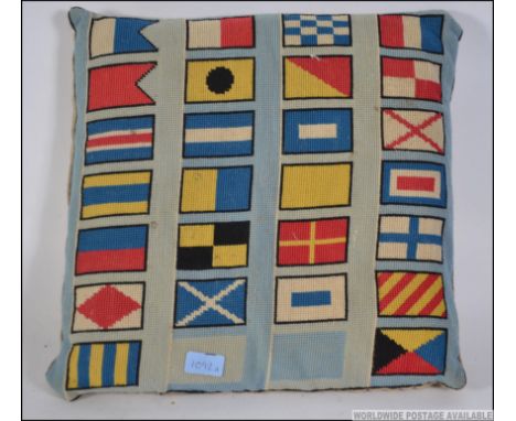 An early 20th century cushion having hand embroidered Berlin work flag decoration. 40cms wide