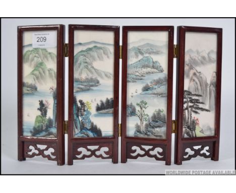 A 20th century miniature handpainted hardwood and ceramic Chinese 4 screen room divider. Measures: 19cm x29cm x 1cm (in first