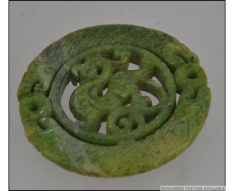 A Chinese oriental carved jade Bi depicting dragons. Measures: 7cms wide.