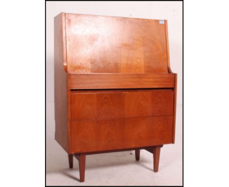 A 1970's light teak wood bureau in the manner of Robert Heritage for Archie Shine being raised on tapered legs. The fall fron