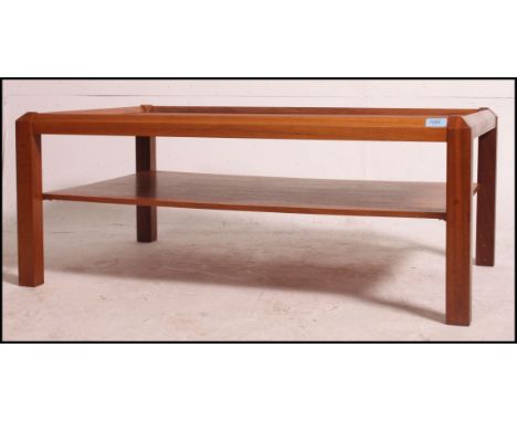 A large vintage mid century teak coffee table with angular legs and under shelf. Measures: 39cm x 99cm x 60.