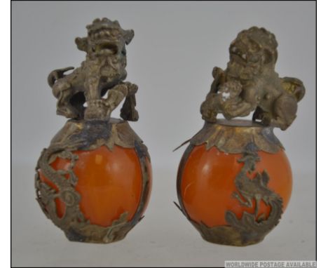 A pair of Chinese temple lions / fu dogs standing on jade balls.  Measures: 6cms high.