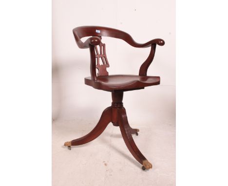 A Victorian style mahogany captains office swivel chair raised on reeded legs with brass castors having panel seat with shape