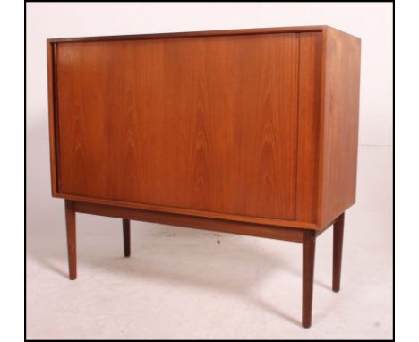 A 1970's Danish influence teak wood tambour fronted small proportioned sideboard cabinet having tapered legs with shelf to in