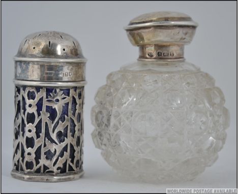 Two pieces of hallmarked silver, the first being a fret pierced, blue glass lined salt shaker with assay marks for London alo