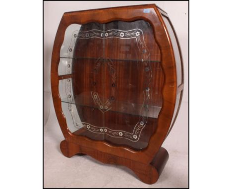 A 1950's post war Art Deco walnut china display cabinet having sliding glass doors with shelved interior all raised on a shap