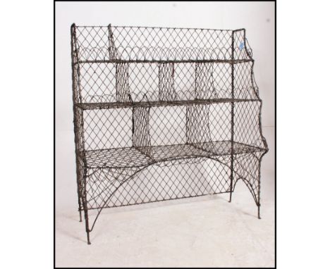 A vintage mid century metal shoe rack of wire work form having sectional upright body