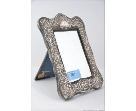 A silver hallmarked easel mirror, having a silver surround with central mirror panel. Measures: 20cms high.