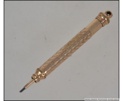 A yellow metal (gold plated) Edwardian propelling pencil with engine turned decoration. Weight 5.1g. Measures 8cms.