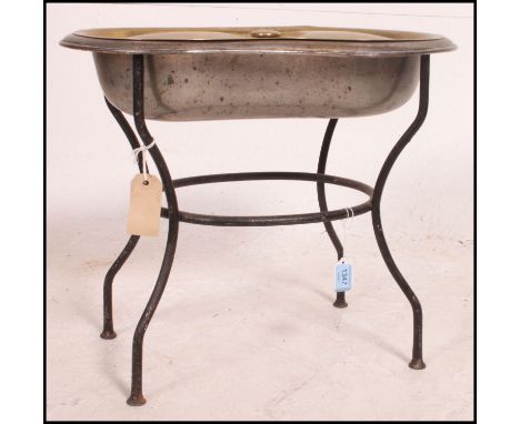 A 19th century cast iron, brass and stainless steel kidney shaped commode basin. The cast iron stand with brass lid to the st