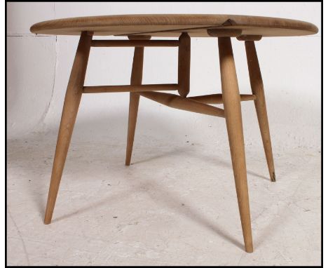 A vintage Ercol blond wood drop leaf circular occasional table raised on tapered legs with drop leaf to one end. Measures(cm)