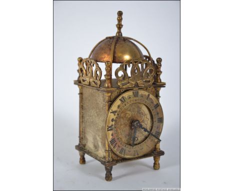 A Smiths English Clocks brass mantel timepiece lantern clock having bell top with roman numeral chapter ring and inset electr