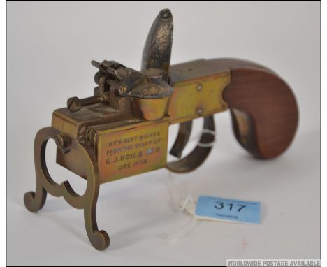 A 1950's Dunhill Tinder Pistol table lighter  with brass mechanism and walnut stock. The side marked for ' With best wishes f