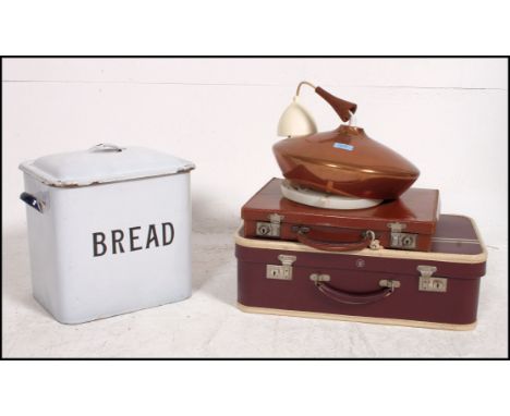 A vintage leather attache case and retro copper pendant shade and an enamel bread bin in white with notation