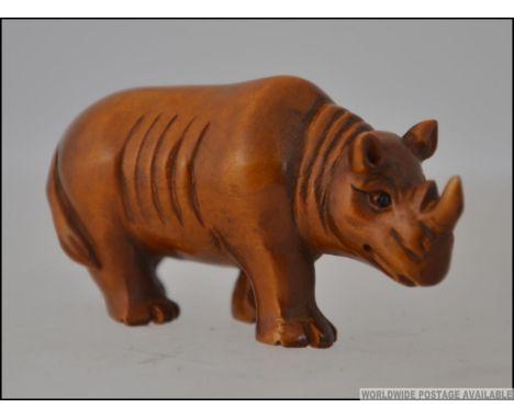 A carved hardwood netsuke in the form of a rhinoceros.   Measures: 6cms long.