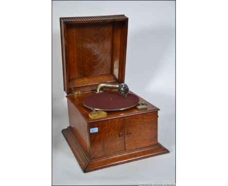 An Edwardian oak cased table top gramaphone record player with handle winder and needles