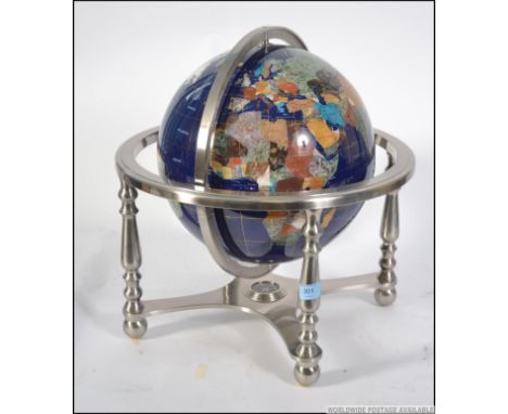 A semi precious stone inlaid celestial day and night globe on blue ground, raised on a chrome gimbal stand with inset compass