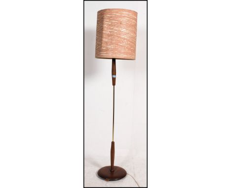 A 1970's retro teak standard lamp with circular base and turned column complete with the original shade. Measures: 176cm x 34