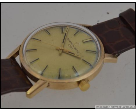 A 1970's 9ct gold gentlemans vintage Eterna Matic 100 wristwatch. The gilded dial with baton numerals having faceted hands se