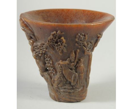 A GOOD CHINESE HORN LIBATION CUP carved with figures and foliage. 5.5ins high.