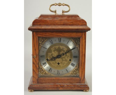 FRANZ HEMIE. AN OAK CASED BRACKET CLOCK with  Westminster chime, brass dial, silvered chapter ring and brass carrying handle.