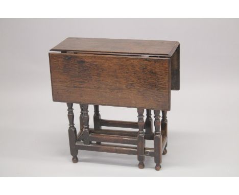 AN 18TH CENTURY OAK DROP FLAP TABLE with end drawer, turned legs with gate leg action and plain uniting stretchers. 11ins dee