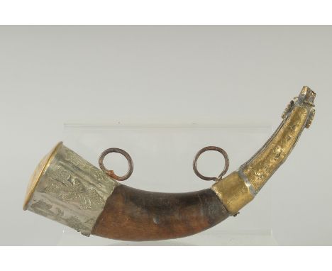 AN EARLY ISLAMIC HORN AND BRASS MOUNTED POWDER FLASK. 11ins long.