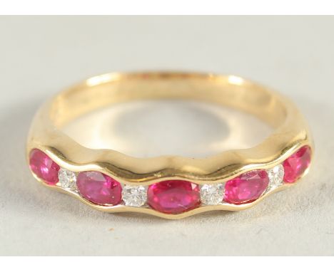 AN 18CT YELLOW GOLD, RUBY AND DIAMOND HALF HOOP RING.