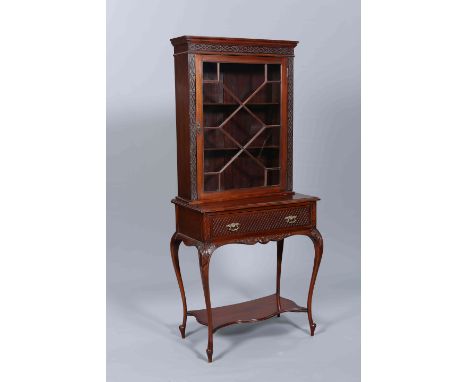 A LATE VICTORIAN MAHOGANY CABINET ON STAND, the case with blind fretwork carving and astragal glazed door, the base with blin