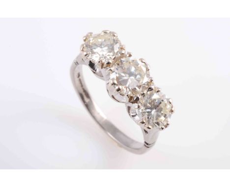 A DIAMOND RING, CIRCA 1880, the three slightly graduating brilliant cut diamonds each claw set in a heavily pierced detail mo
