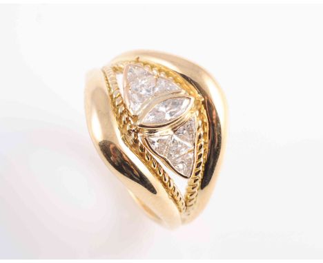A DIAMOND RING, the collet set marquise cut diamond set slightly raised between eight trillion cut collet set diamonds, set i